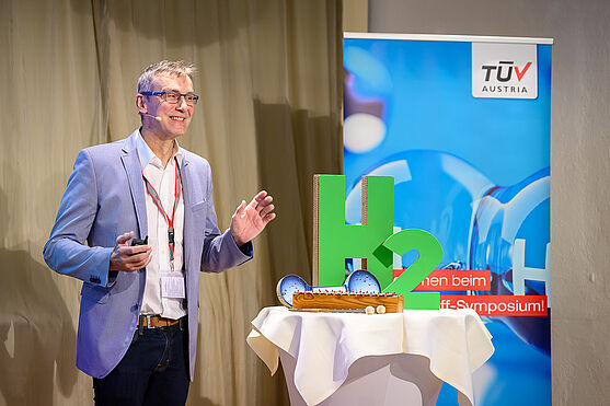 Im ersten Vortrag des Tages, gab es durch Christoph Haase (TÜV AUSTRIA) ein interessantes Update zu den Wasserstoff-Regelwerken.<br /> Mann hält Vortrag vor Publikum