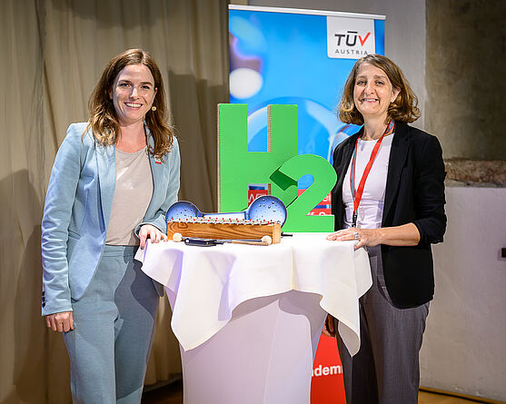 Zwei freundlich lächelnde Damen an einem Stehtisch