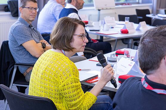 Fragen aus dem Publikum konnten im Anschluss an die Fachvorträge direkt von den Expert:innen beantwortet werden!<br /> Dame aus dem Publikum spricht in Handmikrofon