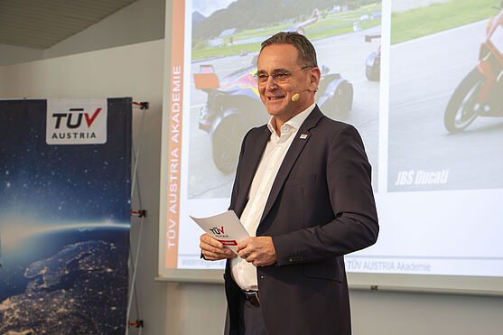 Jochen Bognar (TÜV AUSTRIA) in einer Doppelrolle: er glänzte sowohl als eine Hälfte des Moderationsduos als auch als Vortragender mit dem Erfahrungsbericht: Stahlbau made in China.<br /> Mann hält Vortrag auf der Bühne.