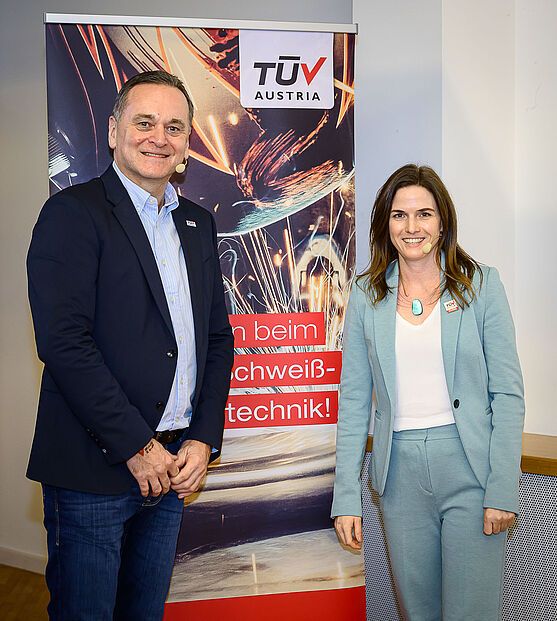 Ebenfalls gastfreundlich und mit klarem Blick auf die Themen der nächsten beiden Tage - beides hatte das Moderatorenteam Sabine Redlich und Jochen Bognar.<br /> Ein Mann und eine Frau im Businessautfit im Schloss Seggau vor einem Aufsteller. Sie lächeln in die Kamera.