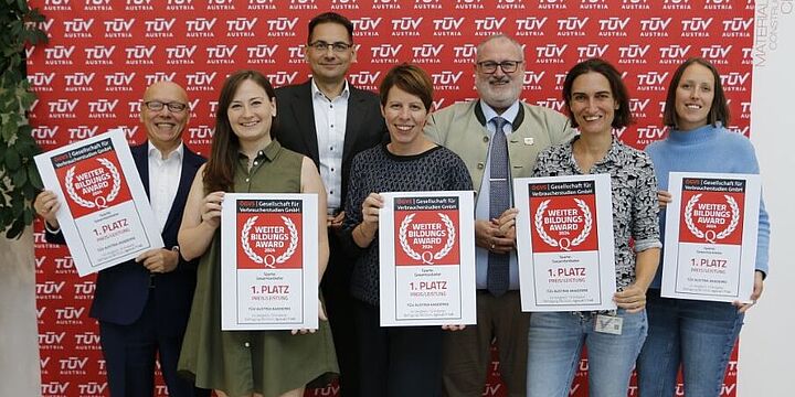 Gruppenfoto inklusive Weiterbildungs-Award in Papierform.