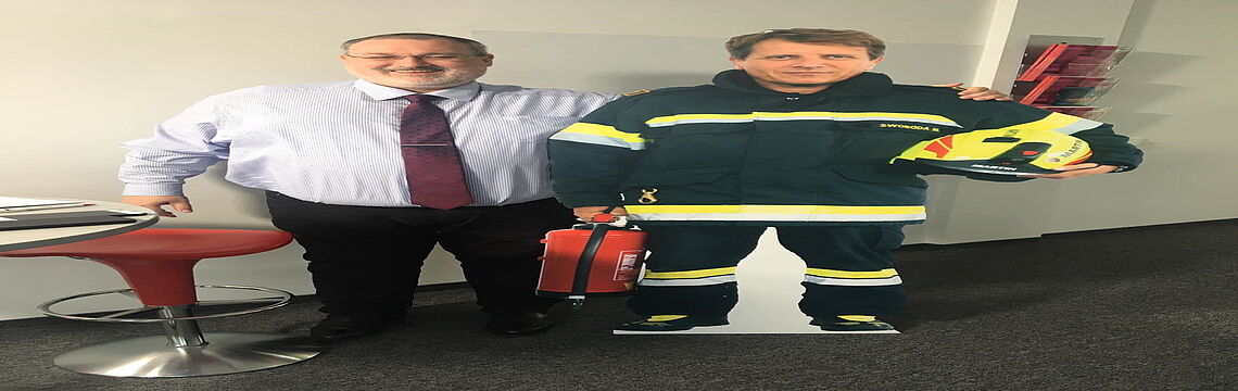 So geht Hygiene: Thomas Rochowansky, Leiter Lerndienstleistungen der TÜV AUSTRIA Akademie umarmt seinen "Pappkollegen" Martin Swoboda, Brandschutzexperte des TÜV AUSTRIA.
