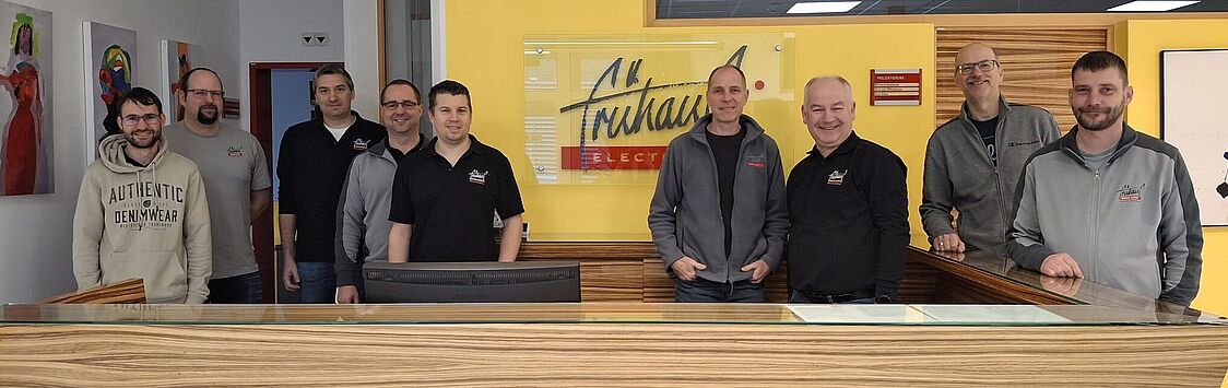 Gruppenfoto Firma Frühauf. Neun freundlch lächelnde Herren