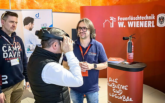 Mann mit VR Brille an einem Ausstellerstand.