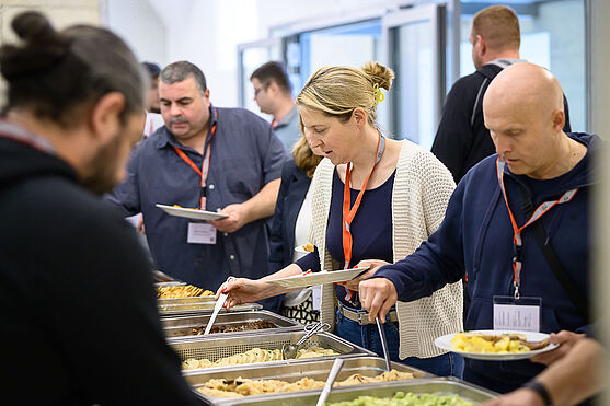 Teilnehmer:innen bedienen sich am Mittagsbuffet.