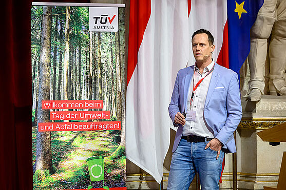 Mann auf Bühne hält Vortrag.