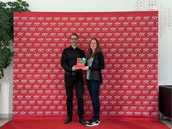 Neben einem Mann (Autor mit Buch) steht eine Frau und hält auch das Buch