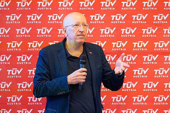 Den Anfang machte Dipl.-Ing. Ernst Piller (BMASGPK – Zentral-Arbeitsinspektorat, techn. Arbeitsschutz). Passend zur Jahreszeit, informierte er über die neue Hitzeschutzverordnung.<br /> Mann mit Handmikrofon hält Vortrag.