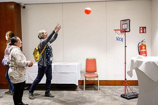 Dame wirft Basketball in Korb.