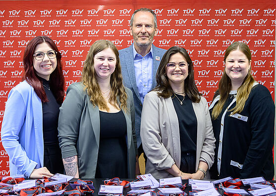 Vier Damen und ein Herr lächeln freundlich. Vor ihnen liegen Namenskärtchen für die Teilnehmenden.