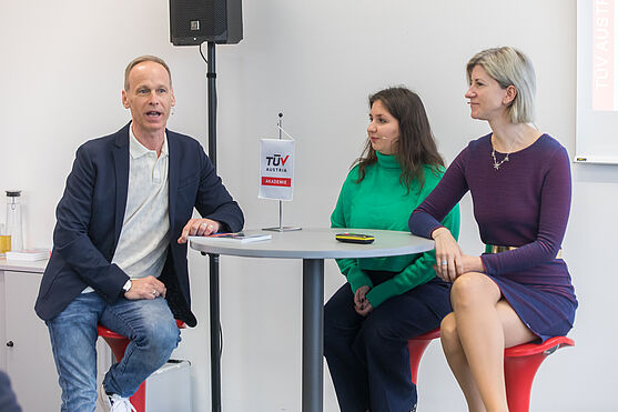 Runder Tisch mit einem Herren und zwei Damen im Gespräch