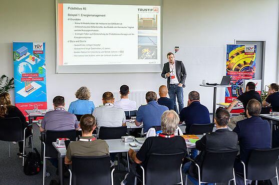 Andreas Gruber, MMSc (TÜV AUSTRIA TRUSTIFAI GmbH) mit spannendem Ausblick in die nahe Zukunft: KI als Gamechanger im Gebäudebetrieb. <br /> Mann spricht vor Publikum