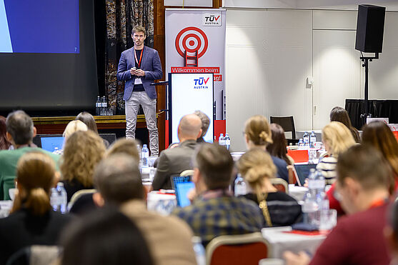 Mann hält Vortrag vor Publikum.