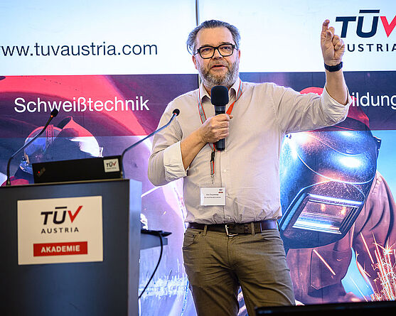 Anschließend folgte ein Vortrag in englischer Sprache von Eric Cruysweegs (TÜV AUSTRIA BELGIUM NV). New Ways in Pipeline Weld Inspection: Qualification of Phased Array Ultrasonic Inspection.<br /> Ein Mann mit Brille erklärt mit ausladender Gestik etwas.