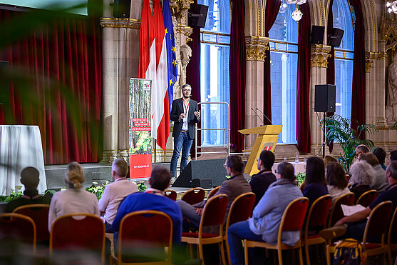 Man hält Präsentation auf Bühne.