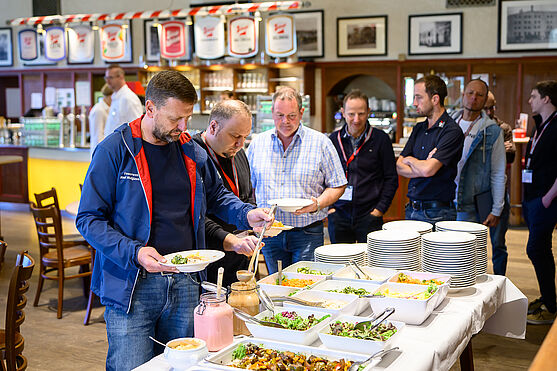 Nach einem informativen Vormittag, ging es in die wohlverdiente Mittagspause. Mahlzeit!<br /> Menschen bedienen sich am Mittagsbuffet.