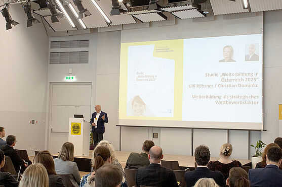 Sprecher der Plattform für berufsbezogene Weiterbildung und Geschäftsführer der TÜV AUSTRIA AKADEMIE, Christian Bayer „Das Jahrbuch Weiterbildung landet punktgenau dort, wo es gebraucht wird – in der betrieblichen Praxis.“<br /> Mann hält Vortrag vor Publikum