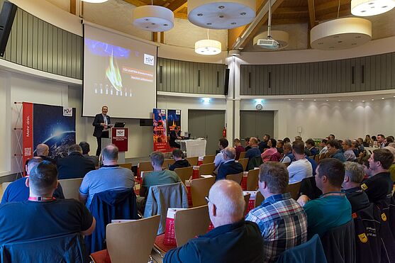 Die Teilnehmer/innen des Brandschutztages sitzen im Saal und hören einen Vortrag.