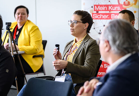 Dame aus dem Publikum spricht in ein Mikrofon.