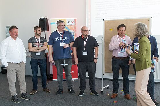 Gruppenfoto. Männern werden Preise überreicht.