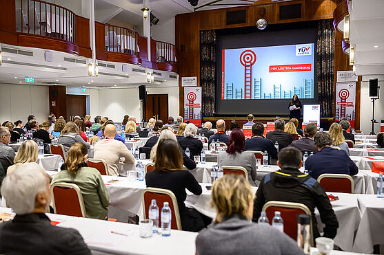 Dame hält Vortrag auf Bühne.