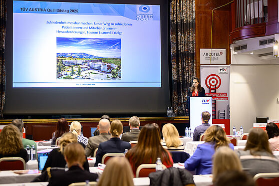 Dame hält Präsentation auf einer Bühne.