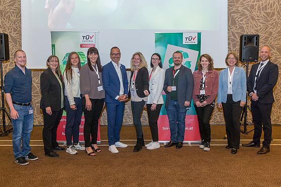 Ein Gruppenfoto mit Mitarbeiterinnen und Mitarbeitern des TÜV AUSTRIA. Sie lächeln in die Kamera.