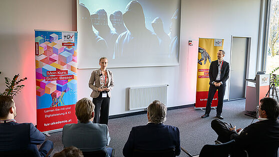 Eine Dame und ein Herr halten einen Vortrag.