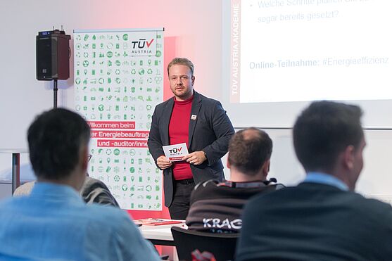 Bernhard Maitz (TÜV AUSTRIA Akademie) hieß die Teilnehmer:innen herzlich willkommen und moderierte die Veranstaltung im Duett mit Karin Newald gewohnt charmant.<br /> Mann im Sakko, hält Moderationskarten in der Hand und steht vor Publikum.