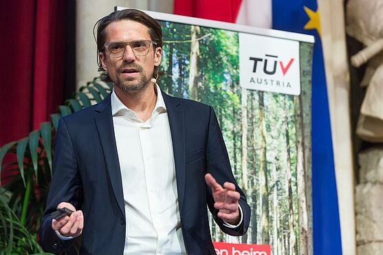 Mann mit Brille, Hemd und Sakko hält Vortrag auf der Bühne.