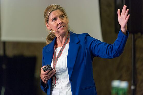 Monika Brom, eine Frau in blauem Business gewand, referiert über non financial reporting und ökologische indikatoren