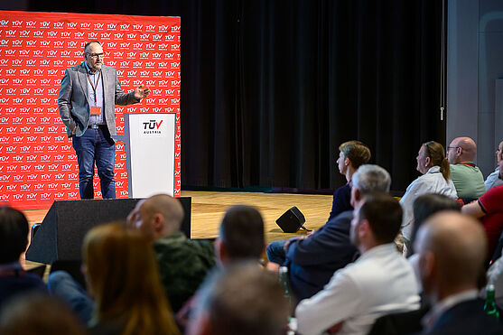 Mann hält Vortrag vor Publikum.