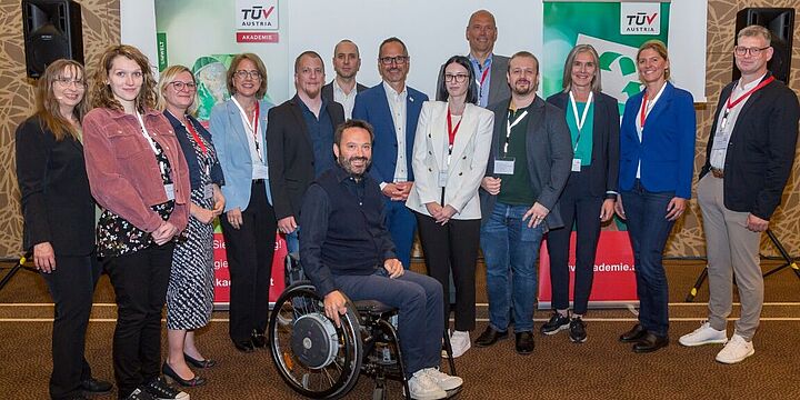 ein Gruppenbild von den Referentinnen und Referenten am TÜV AUSTRIA Symposium CSR und Nachhaltigkeit 2024 im Vortragssaal des Austria Trend Hotels Savoyen in Wien