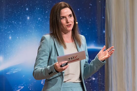 Dame mit Headset und Moderationskarten in der Hand.