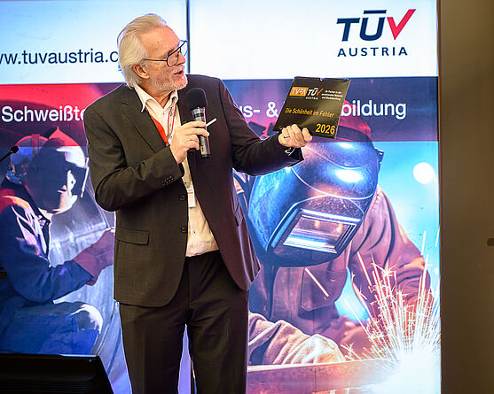 Gerhard Höltmann (TÜV AUSTRIA GMBH): Schäden an Druckgeräten: Ein Inspektor klärt auf<br /> Ein Mann mit weißen Haaren und Brille spricht in ein Mikro