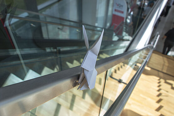 <br /> Origamihaft gefalteter Papierhause auf Treppengeländer