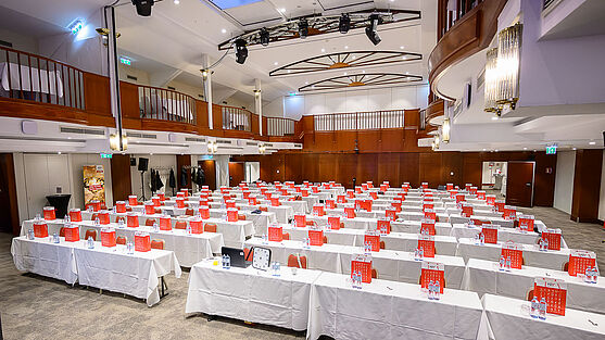 Veranstaltungsraum mit Tischen und Stühlen.