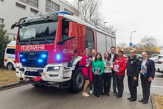 Gruppe Menschen neben einem Feuerwehrauto
