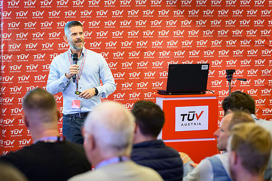 Ing. Alexander Halwachs (TÜV AUSTRIA) mit aufschlussreichen Informationen zum Thema Brandfall bei Aufzügen – Evakuierungsaufzüge.<br /> Mann hält Vortrag