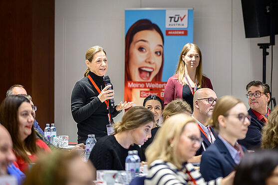 Dame aus dem Publikum spricht in ein Handmikrofon.