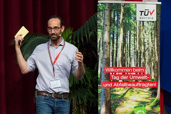 Marcel Krejc, MatWash-CleanTec sprach über Kreislaufwirtschaft & Ressourcenoptimierung.<br /> Mann mit Brille, Bart und Hemd hält einen Vortrag auf einer Bühne.