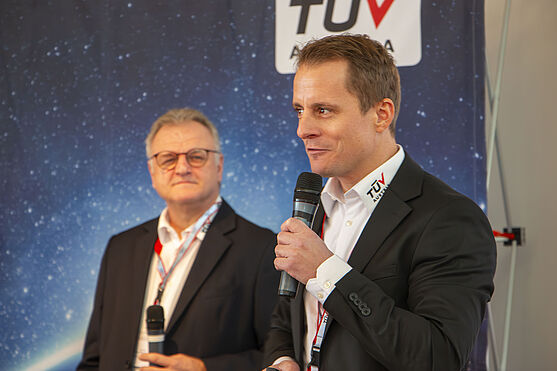 Erich Fössleitner & Alexander Mastnak (TÜV AUSTRIA) lieferten ein Normenupdate und damit den ersten Vortrag des Tages.<br /> Zwei Männer in Sakko und Hemd auf der Bühne.