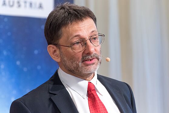 Herr im Anzug hält Präsentation.