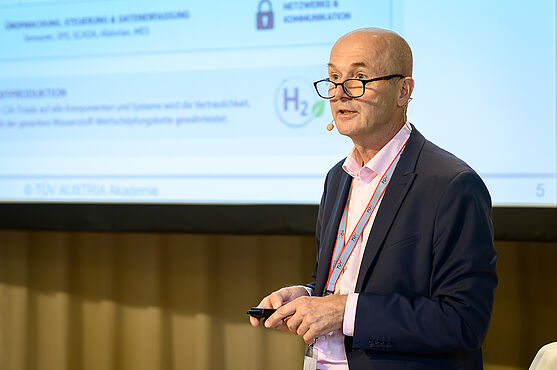 Alexander Zeppelzauer (TÜV AUSTRIA) lieferte aufschlussreiche Informationen aus den Bereichen Cybersecurity, Business Continuity- und Notfallmanagement bei der Wasserstoff-Produktion.<br /> Mann hält Vortrag