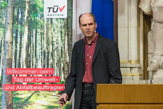Pfandsystem für Einweggetränkeverpackungen. Wo steht Österreich im internationalen Vergleich? Diese Frage beantwortete Peter Beigl, Universität für Bodenkultur Wien, Institut für Abfall- und Kreislaufwirtschaft<br /> Mann mit Hemd und Sakko hält Präsentation.