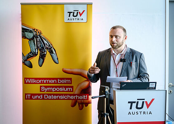 Mann steht am Rednerpult und spricht.