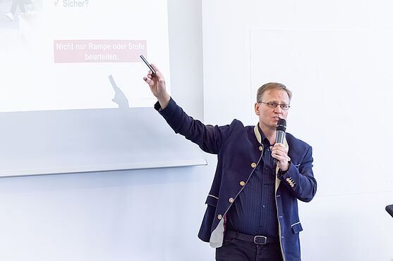 Der Nachmittag stand zum großen Teil im Zeichen von Workshops! Bmstr. Dipl.-Ing. Andreas Kloiber (Sachverständiger TÜV AUSTRIA): Barrierefreiheit in Gebäuden.<br /> Mann hält Vortrag