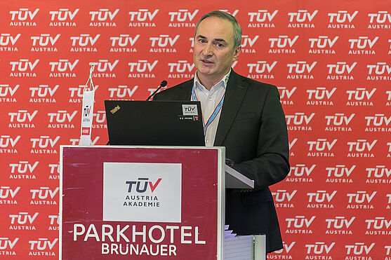 Den ersten Fachvortrag hielt Ing. Günter Rozumilowski (TÜV AUSTRIA): Fluorverbot im Brandschutz – Status quo.<br /> Herr hinter Rednerpult hält Präsentation.