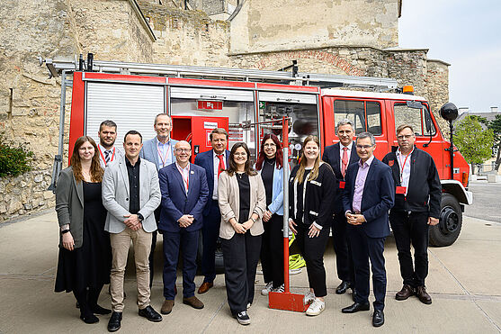Gruppenfoto vor einem Feuerwehrauto.